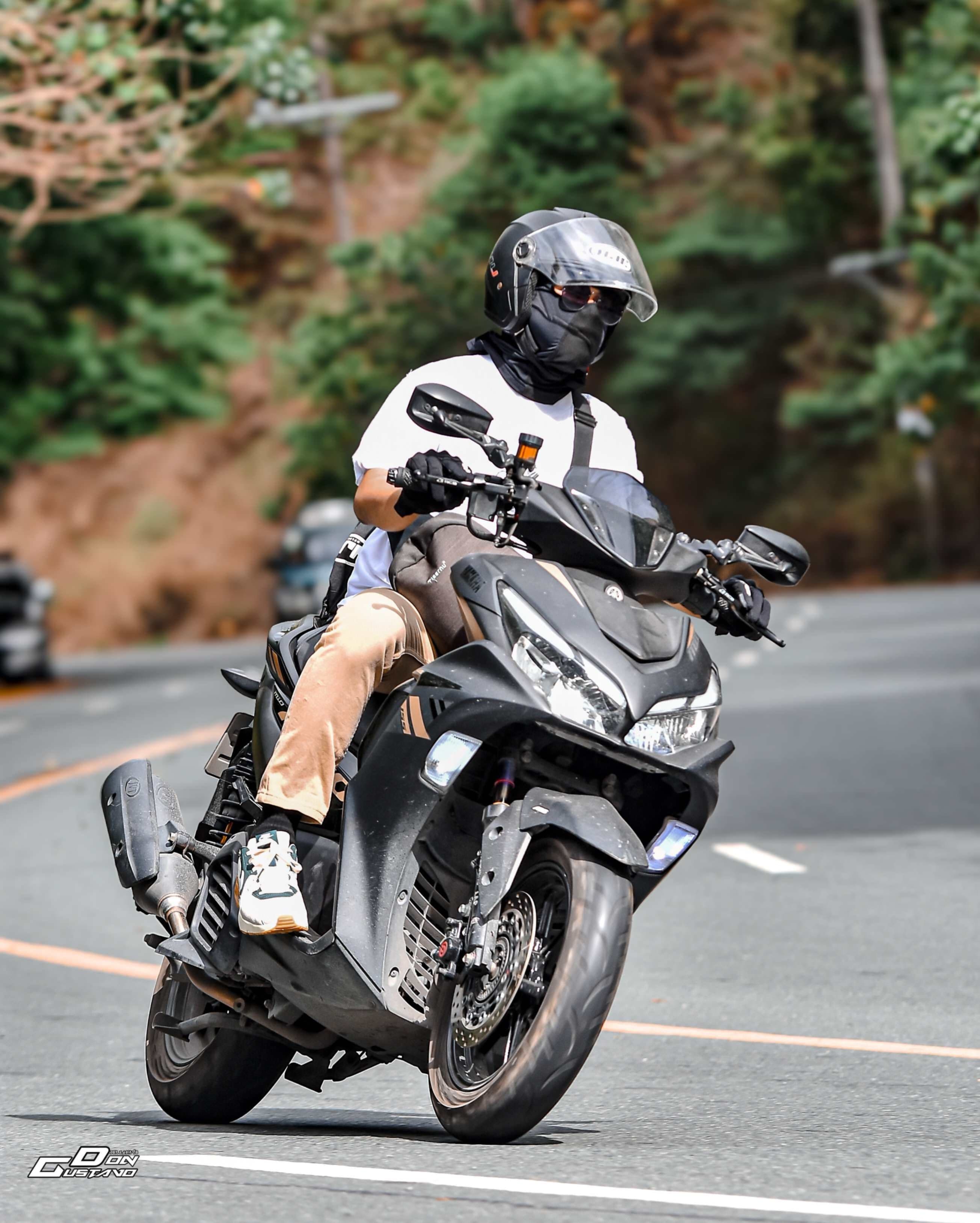 Rider in a white shirt leaning a scooter into a mountain road bend, printed on a phone case